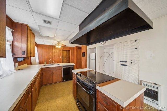 kitchen with visible vents, heating unit, light countertops, black appliances, and a sink