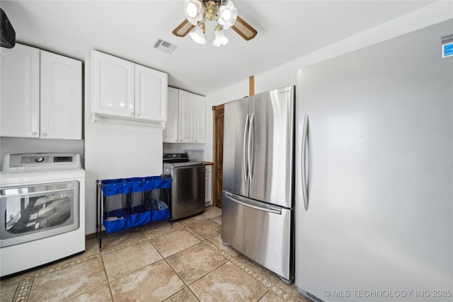 kitchen with washer / dryer, freestanding refrigerator, visible vents, and white cabinetry