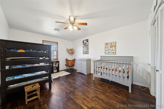 bedroom featuring visible vents, a closet, baseboards, wood finished floors, and a ceiling fan