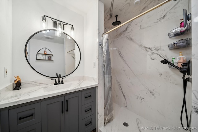 full bathroom with a marble finish shower and vanity