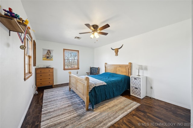 bedroom featuring a ceiling fan, visible vents, baseboards, and wood finished floors