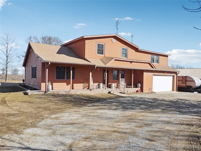 view of front facade with dirt driveway, a porch, an attached garage, and a shingled roof