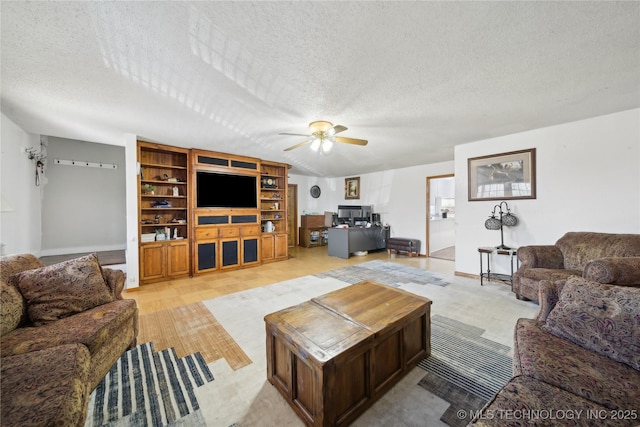 living room with ceiling fan, a textured ceiling, and baseboards