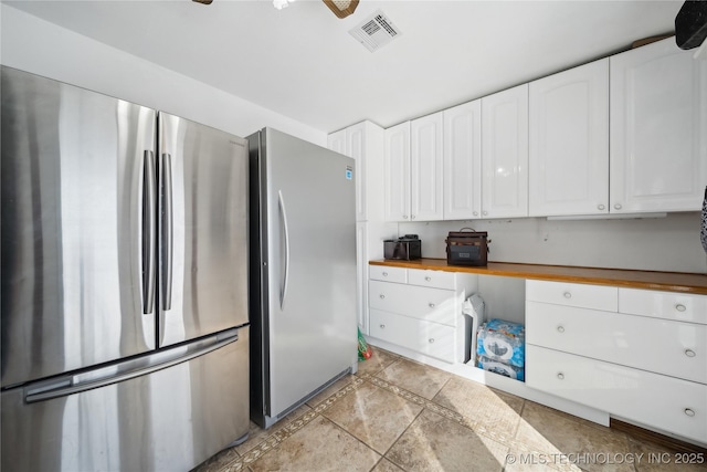 kitchen with ceiling fan, visible vents, white cabinets, and freestanding refrigerator