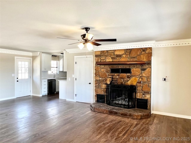 unfurnished living room featuring baseboards, dark wood-type flooring, a stone fireplace, and crown molding