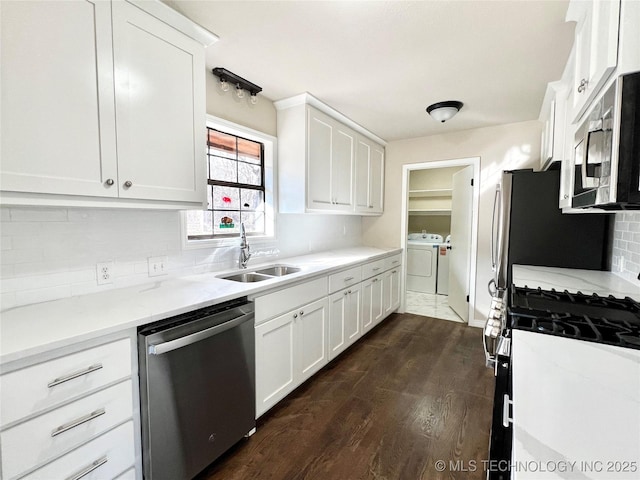 kitchen featuring dark wood-style floors, a sink, stainless steel appliances, white cabinetry, and tasteful backsplash