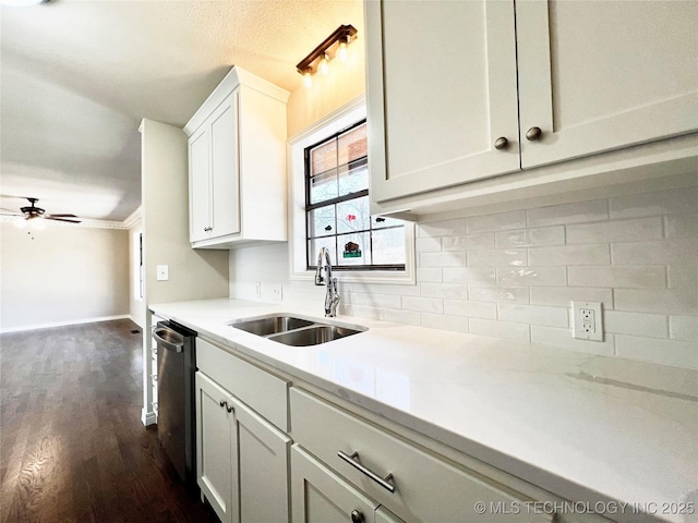 kitchen featuring a sink, stainless steel dishwasher, dark wood finished floors, decorative backsplash, and ceiling fan