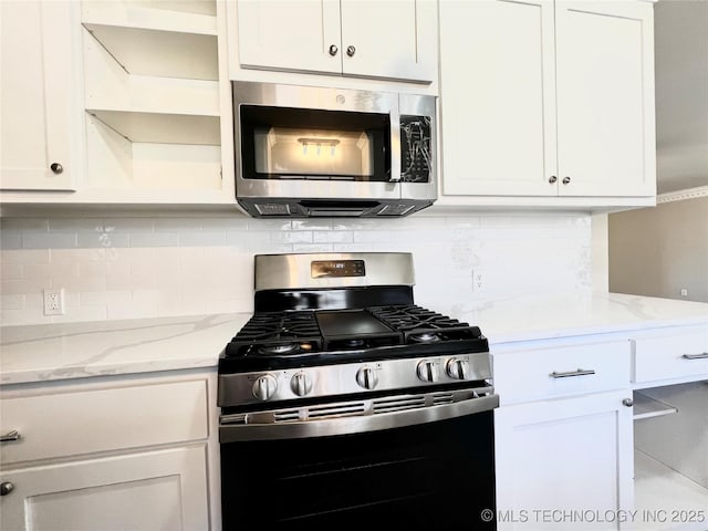 kitchen featuring decorative backsplash, white cabinets, and stainless steel appliances