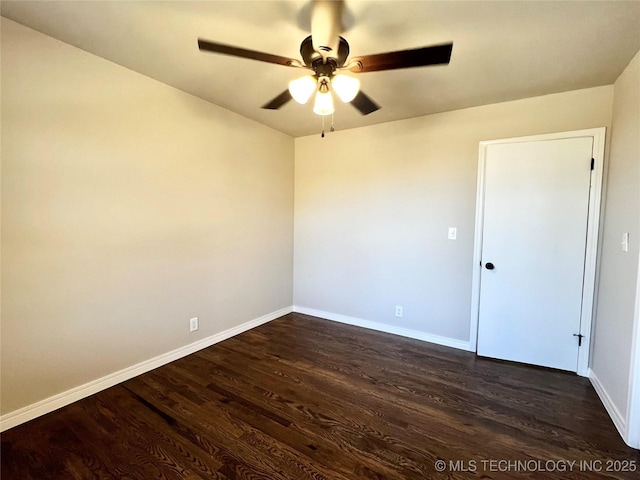 empty room featuring baseboards, dark wood-style floors, and a ceiling fan