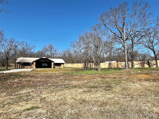 view of yard with an outbuilding, a carport, a pole building, and fence