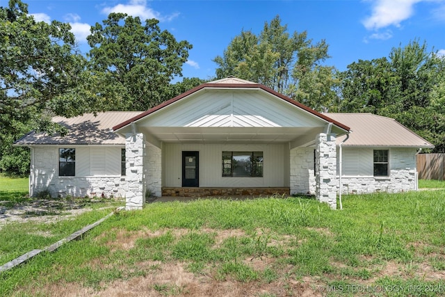 16306 N Javine Hill Rd, Skiatook, OK 74070 - view of front facade with stone siding, a metal roof, a front lawn, and a porch