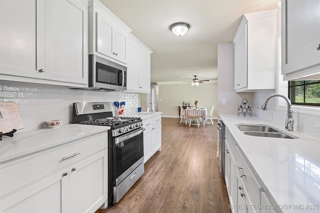16306 N Javine Hill Rd, Skiatook, OK 74070 - kitchen featuring appliances with stainless steel finishes, decorative backsplash, ceiling fan, and wood finished floors