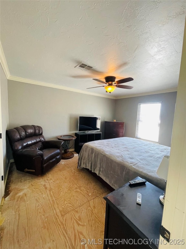 bedroom with a ceiling fan, crown molding, visible vents, and wood finished floors