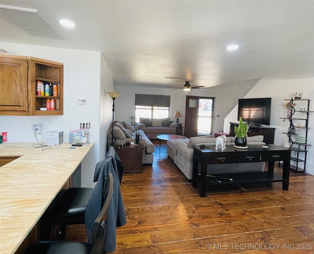 living room featuring dark wood finished floors, recessed lighting, visible vents, ceiling fan, and a textured ceiling