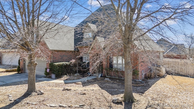 view of front of property featuring driveway, roof with shingles, a garage, and brick siding