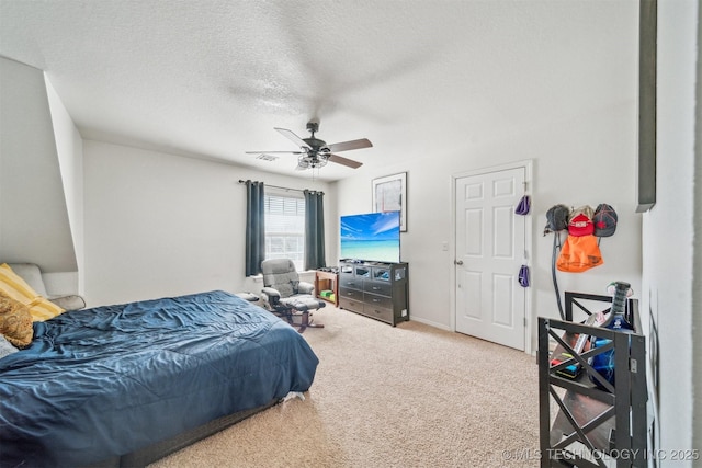 bedroom with a textured ceiling, visible vents, carpet flooring, and a ceiling fan