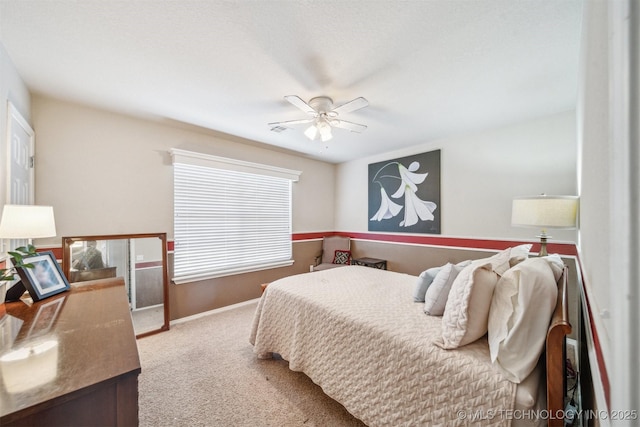 carpeted bedroom featuring ceiling fan, visible vents, and baseboards