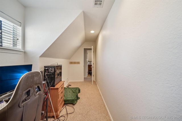 interior space with carpet floors, lofted ceiling, visible vents, and baseboards