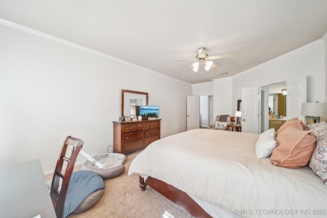 bedroom with light carpet, a ceiling fan, baseboards, ornamental molding, and ensuite bath