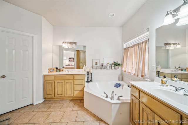 full bath featuring two vanities, a sink, a bath, and tile patterned floors