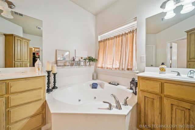 bathroom with visible vents, vanity, and a whirlpool tub