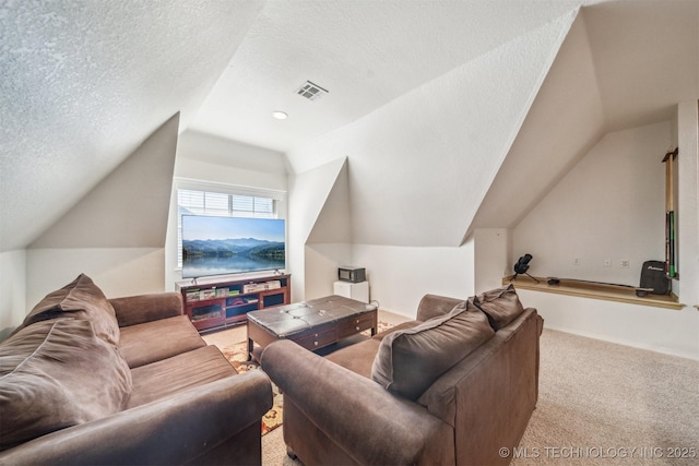 carpeted home theater room featuring visible vents, vaulted ceiling, and a textured ceiling