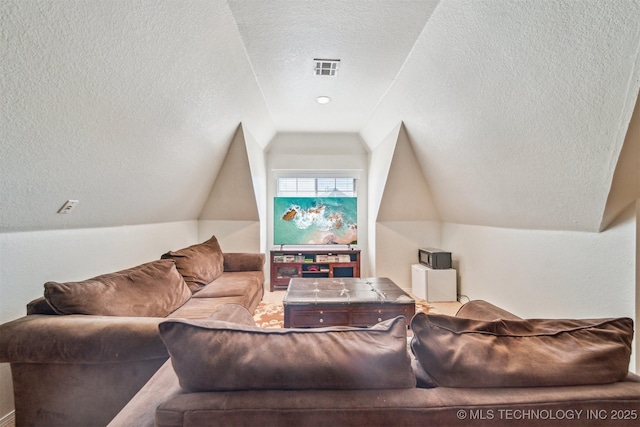 home theater with a textured ceiling, vaulted ceiling, and visible vents