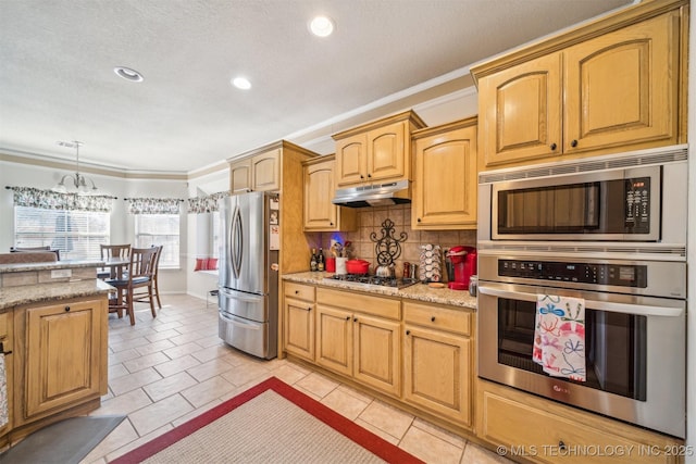 kitchen featuring stainless steel appliances, crown molding, under cabinet range hood, and tasteful backsplash