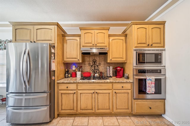 kitchen featuring light tile patterned flooring, under cabinet range hood, stainless steel appliances, light stone countertops, and tasteful backsplash