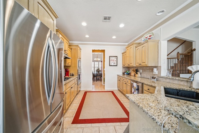 kitchen featuring light brown cabinets, a sink, visible vents, appliances with stainless steel finishes, and decorative backsplash