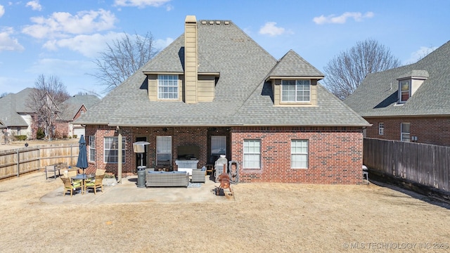 back of property with a patio, brick siding, a shingled roof, and a fenced backyard