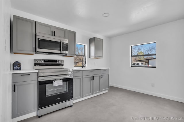 kitchen featuring appliances with stainless steel finishes, a wealth of natural light, and gray cabinetry