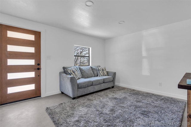 living area with concrete flooring and baseboards