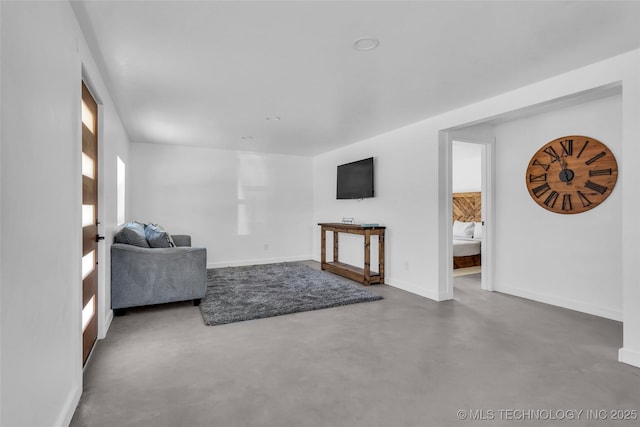 living area with finished concrete flooring and baseboards