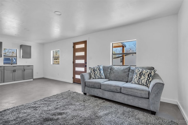 living room with finished concrete floors and baseboards