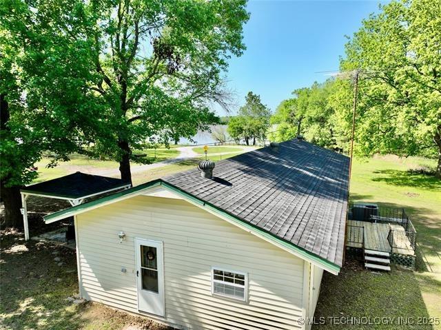 back of house featuring a shingled roof