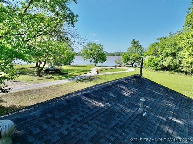 view of community featuring a water view and a lawn