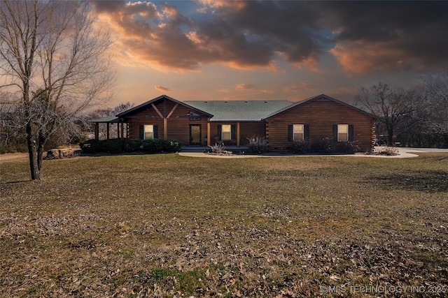 log home with a front lawn and log siding