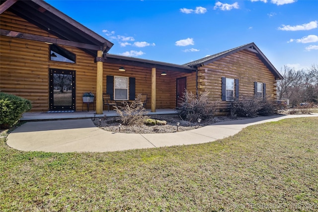 log cabin with a front yard and log siding