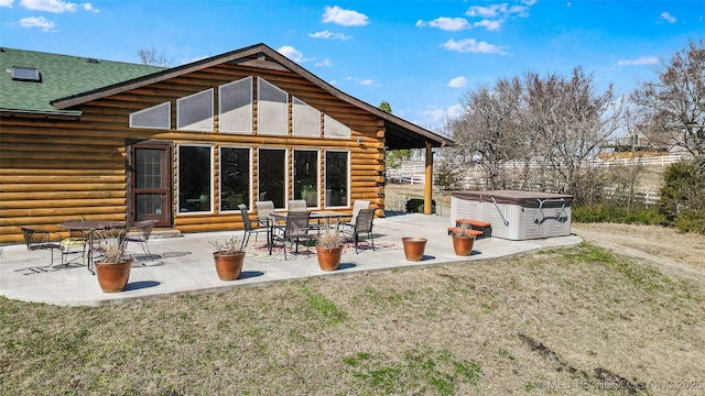 back of property featuring a patio area, log exterior, and roof with shingles