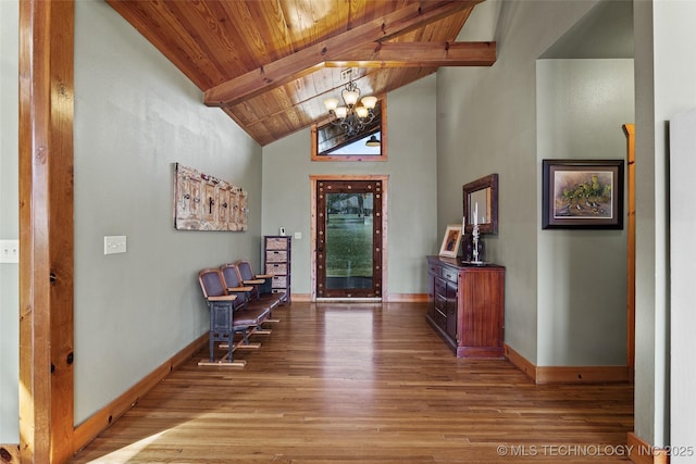 foyer entrance with beam ceiling, a notable chandelier, wood finished floors, wooden ceiling, and baseboards