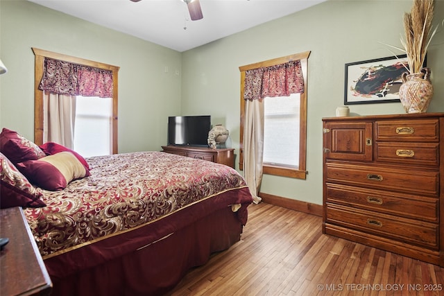 bedroom with ceiling fan, light wood-style flooring, and baseboards