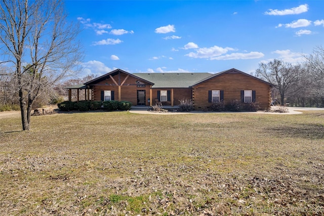 log-style house featuring log exterior and a front lawn