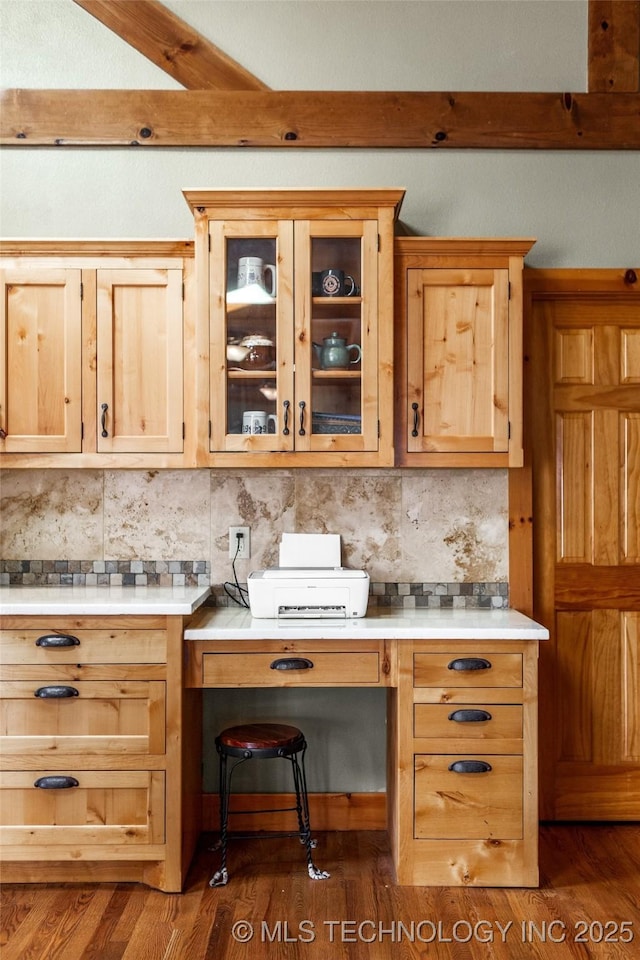 kitchen featuring light countertops, dark wood-type flooring, and backsplash