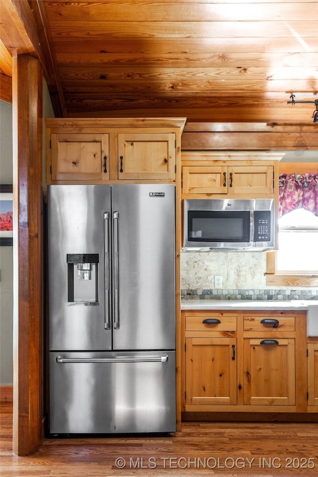 kitchen featuring tasteful backsplash, wooden ceiling, wood finished floors, stainless steel appliances, and light countertops