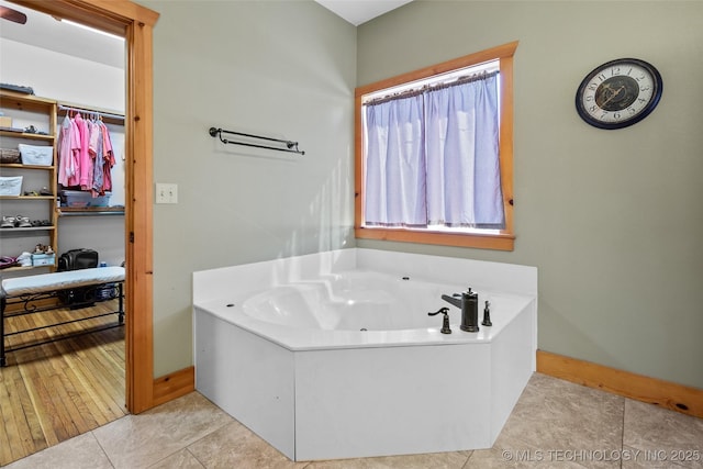 full bathroom featuring baseboards, a bath, and tile patterned floors