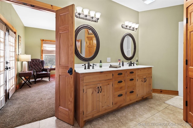 bathroom with double vanity, baseboards, and a sink