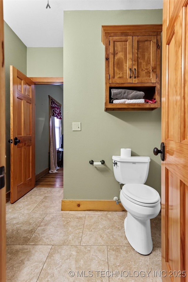 bathroom featuring baseboards, toilet, and tile patterned floors