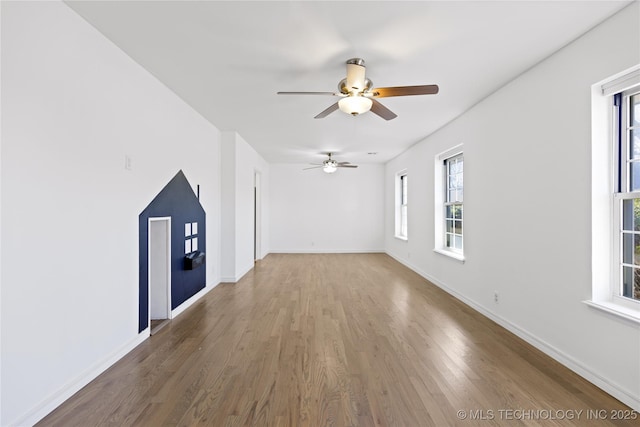 spare room featuring a ceiling fan, baseboards, and wood finished floors