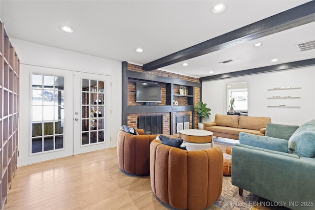 living room featuring a brick fireplace, recessed lighting, wood finished floors, and beamed ceiling